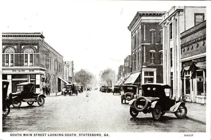 North Main Street, Statesboro, Georgia, looking south. Cars and buildings line the street in a vintage postcard.