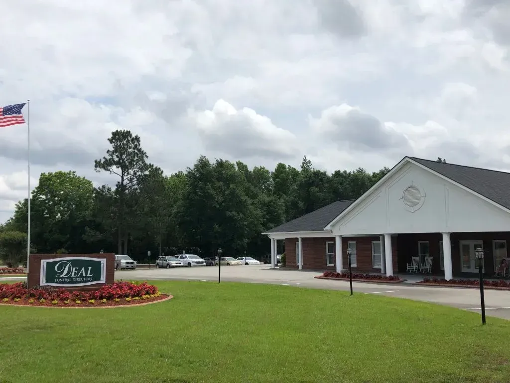 Sign for LEAL Funeral Home and building with US flag.