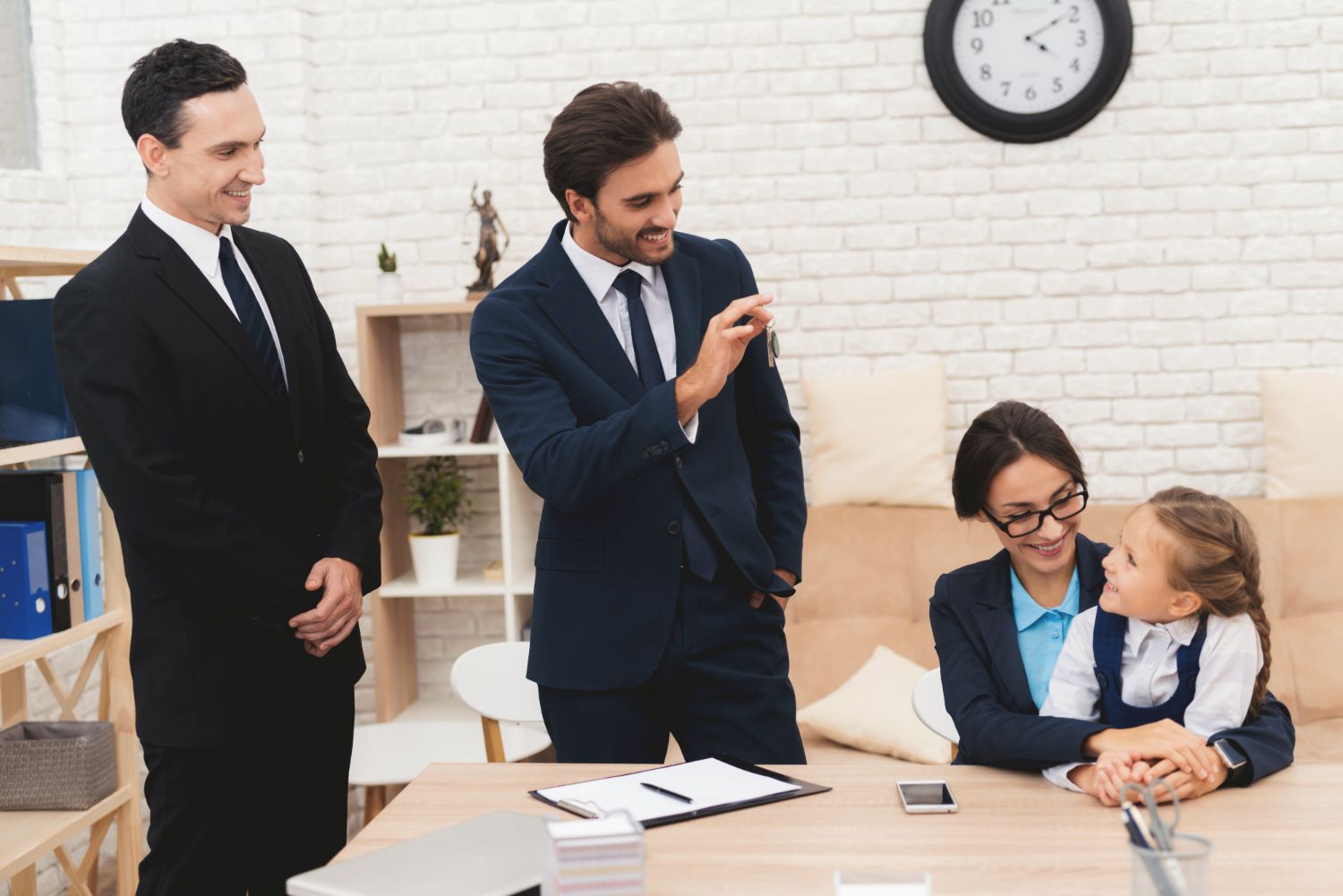 Four businesspeople in a bright office, smiling and talking around a conference table.