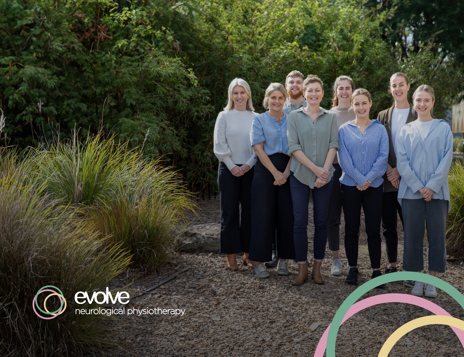 A group of evolve therapists posing for a picture in a park.