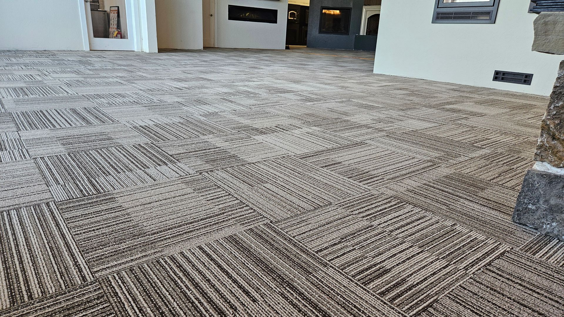 Patterned gray carpet in a modern living room with a fireplace in the background