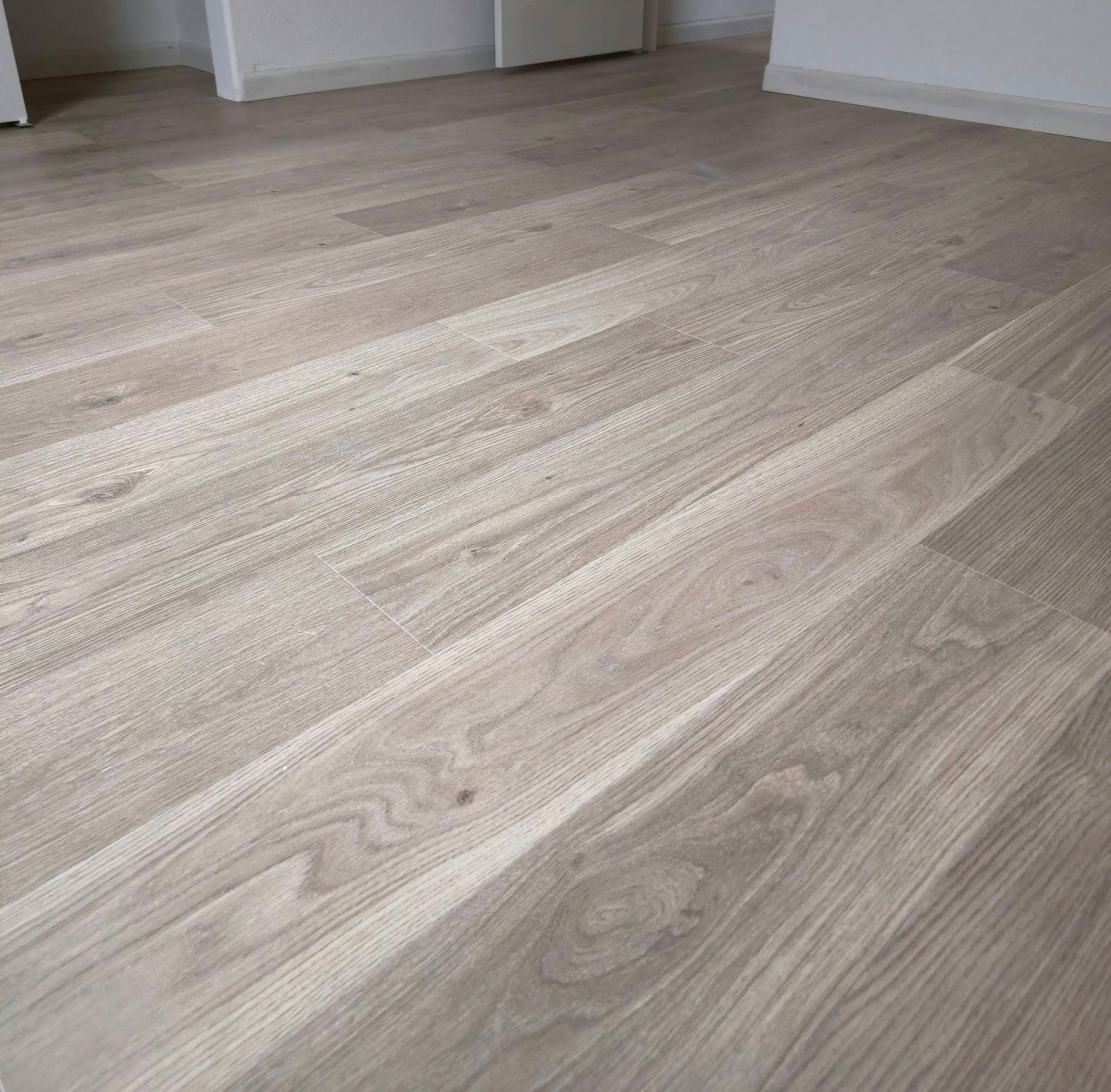 Light wood plank flooring in a bright empty room