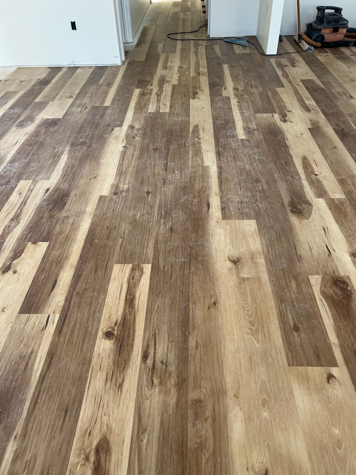 Wood-look flooring installed in an indoor room near a doorway.