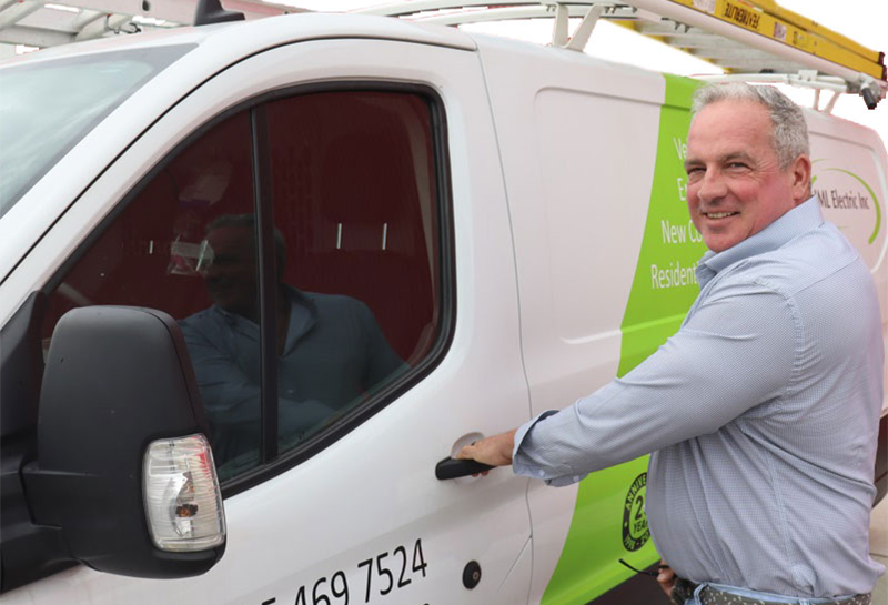 A man is opening the door of a white van