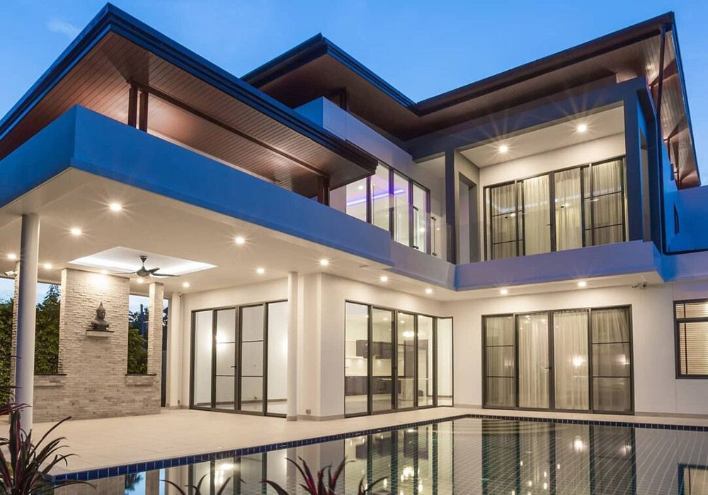 A large house with a swimming pool in front of it.