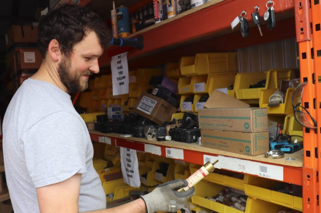 A man is standing in front of a shelf full of tools