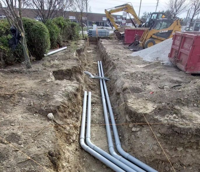 A bunch of pipes are being installed in the dirt