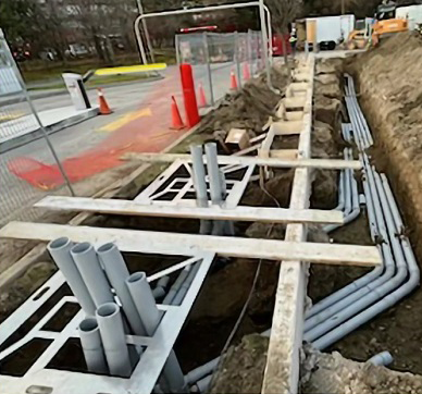 A bunch of pipes are being installed in a trench.
