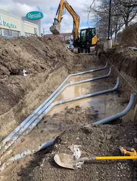 A large yellow excavator is digging a hole in the ground.