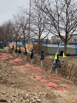A construction site with a lot of dirt and trees in the background.