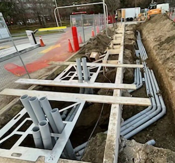 A bunch of pipes are being installed in a trench