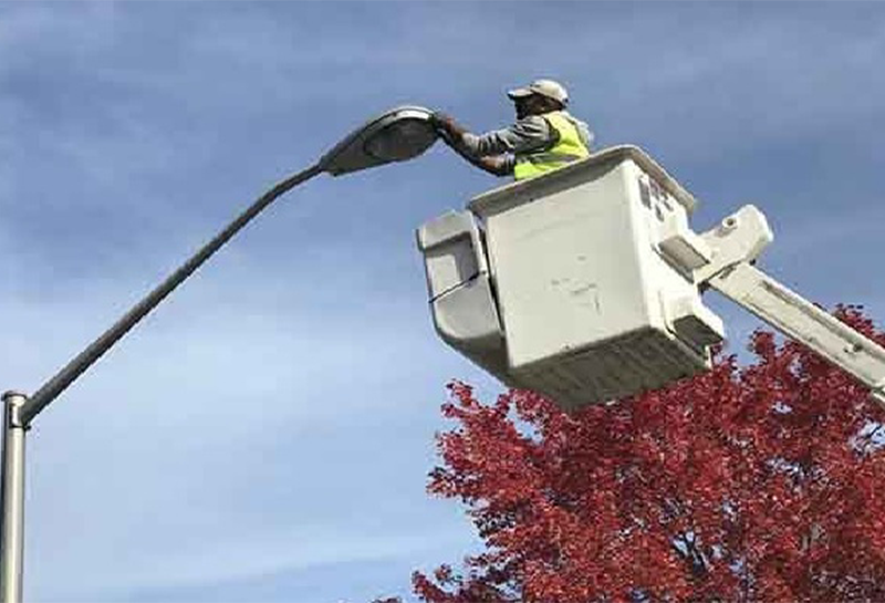 A man is working on a street light in a bucket.