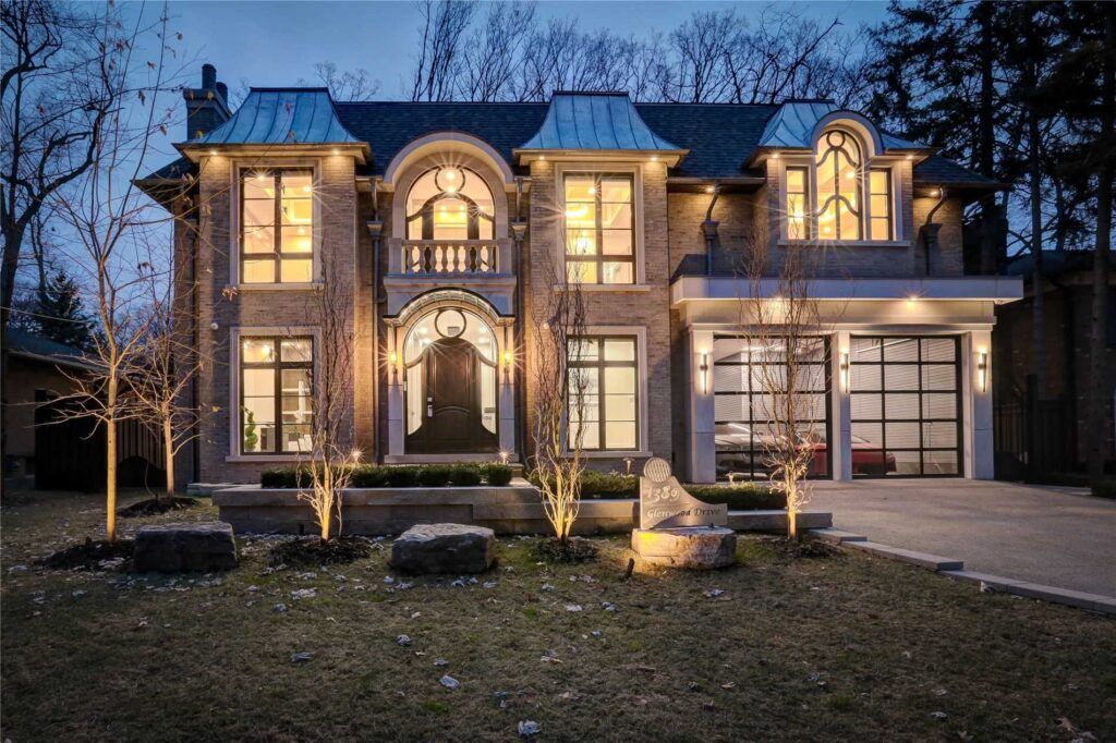 A large house with a lot of windows is lit up at night.