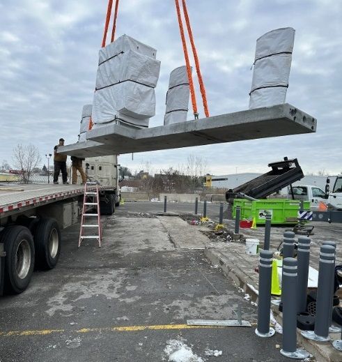 A large concrete slab is being lifted by a crane