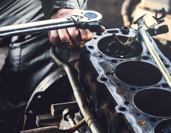Man performing engine repairs | Rockford Auto Inc