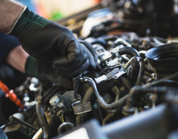 Man performing preventative maintenance on engine of vehicle | Rockford Auto Inc