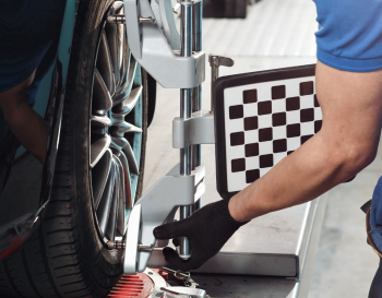 Man performing wheel alignment service | Rockford Auto Inc