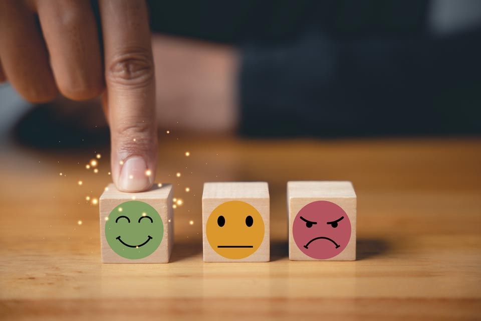 Eine Person zeigt auf einen Würfel mit einem Smiley darauf.