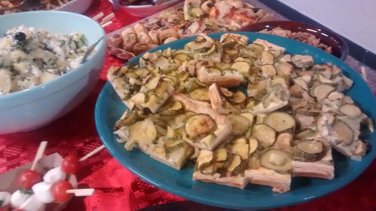 Piatti di macedonia di frutta a fette su una tovaglia rossa, con una ciotola di insalata mista a sinistra.