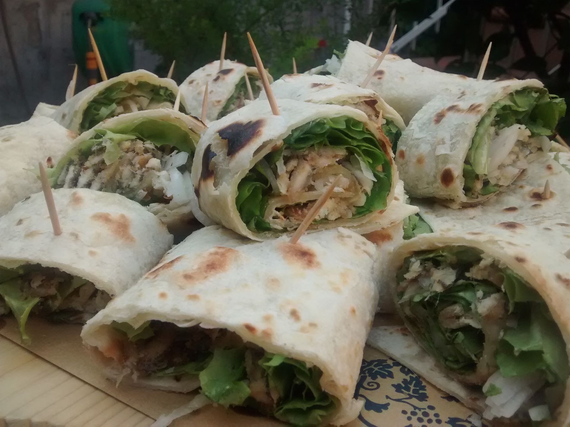 Piadine ripiene di verdure e ortaggi tritati, disposte su un tagliere di legno.