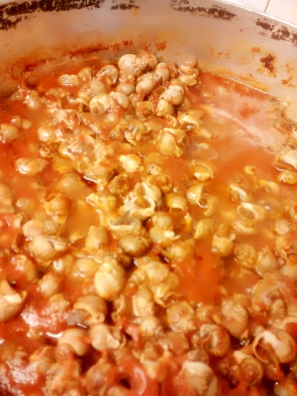 Primo piano di chicchi di popcorn in una pentola con salsa all'arancia o condimento che sobbolle intorno.