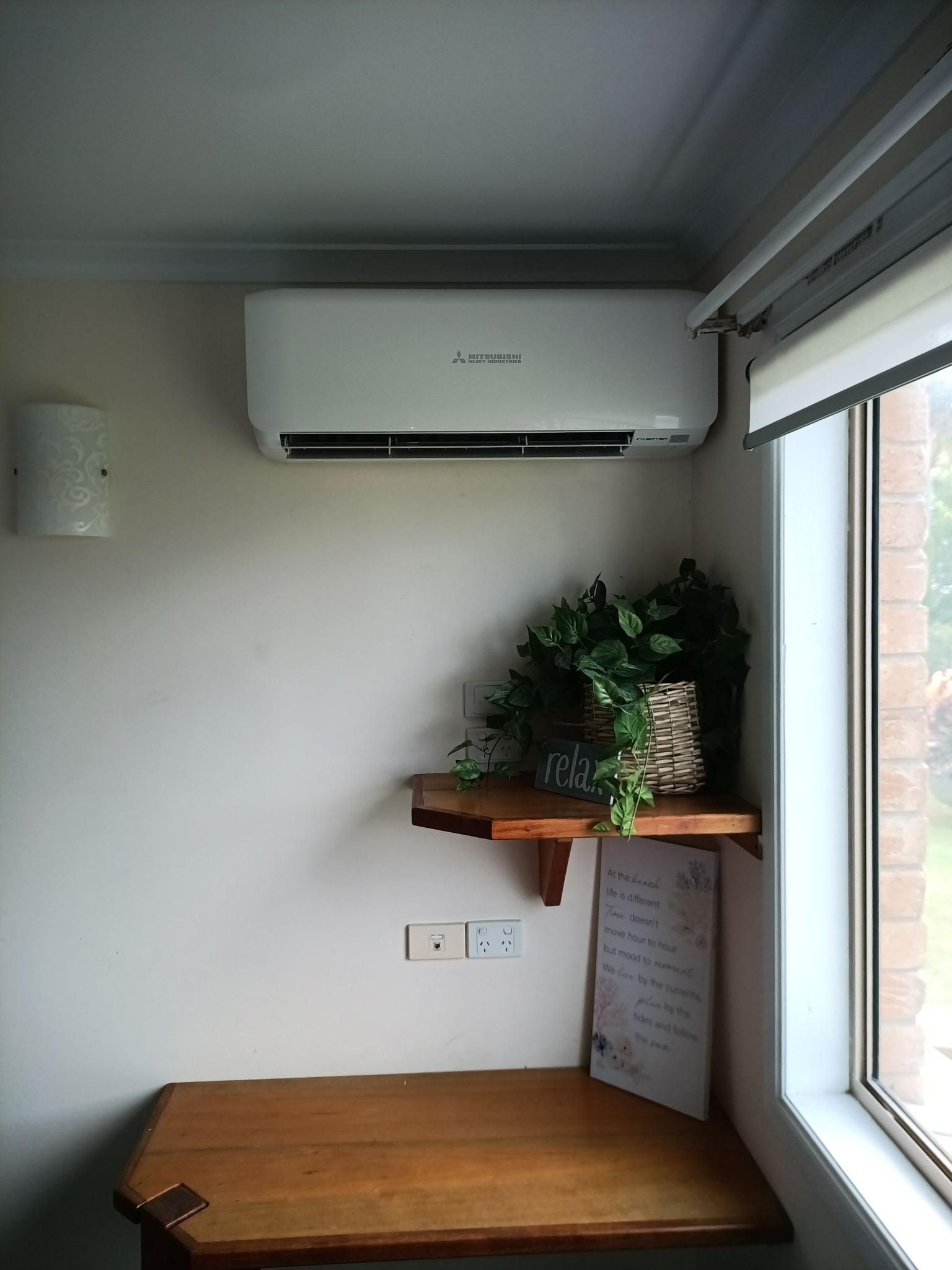 A Room With a Desk and a Window With a Plant on a Shelf — Instant Spark Electrical in Glen Isla, QLD