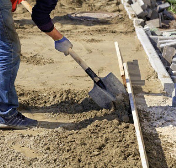 Worker Preparing for Driveway Drain Installation Worker Preparing for Driveway Drain Installation