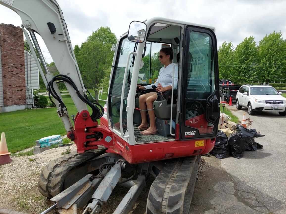 A Woman Operating a Mini Excavator