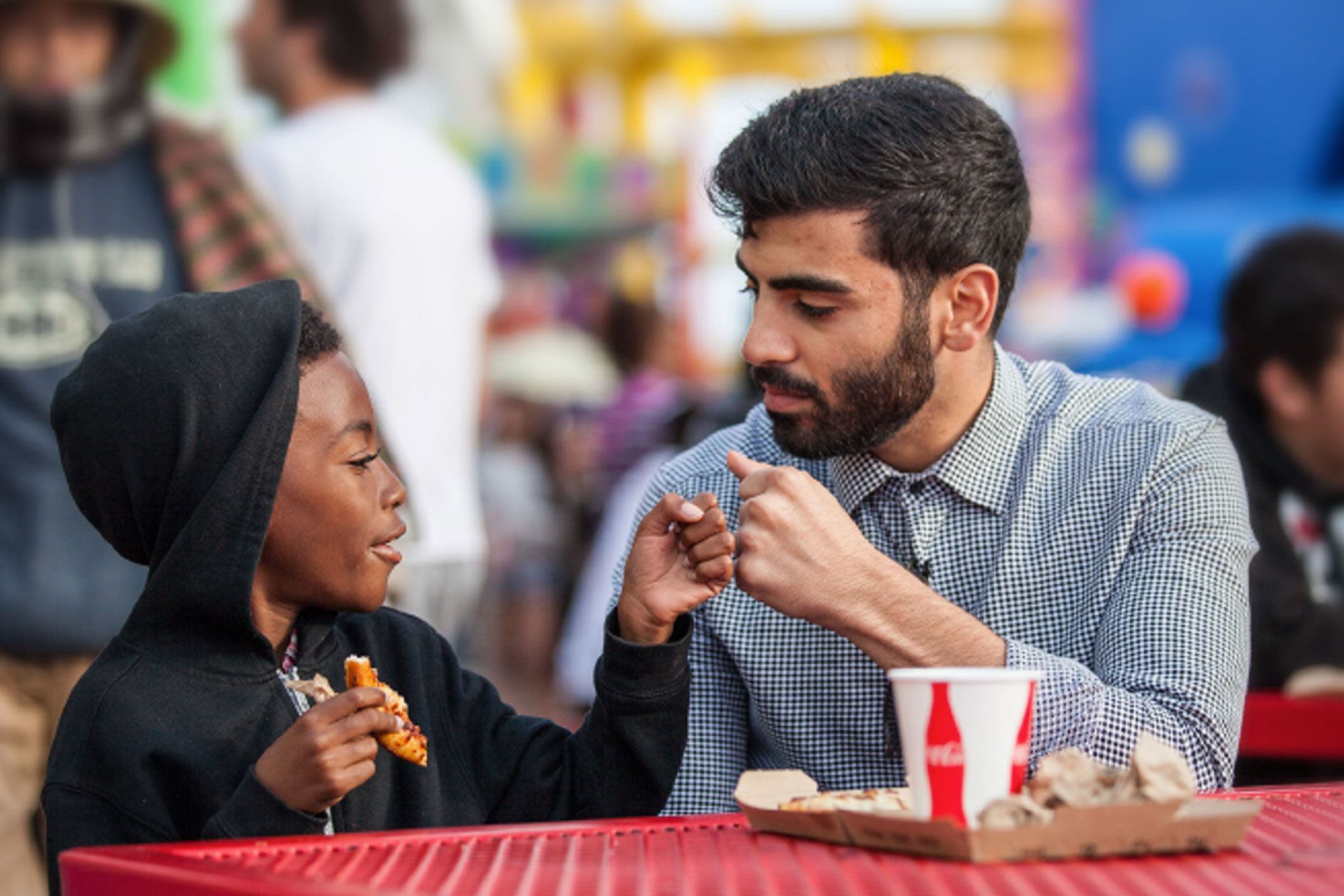 A man and a boy are sitting at a table eating food.