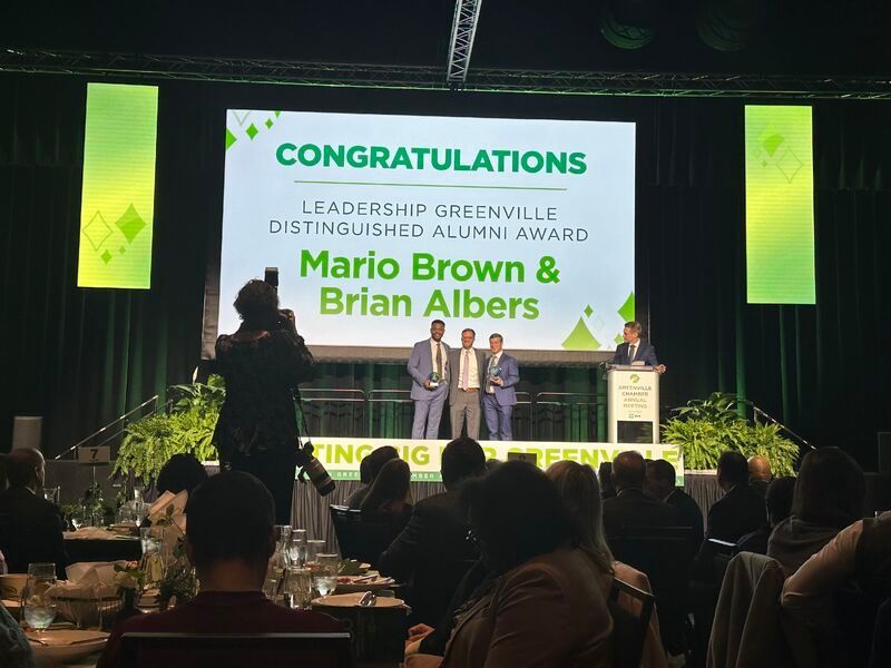 Award stage with “Congratulations” backdrop honoring Mario Brown and Brian Albers as Leadership Excellence award winners