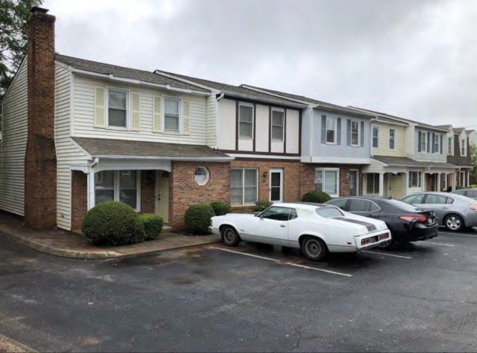 Apartment row with parked cars in front on a cloudy day