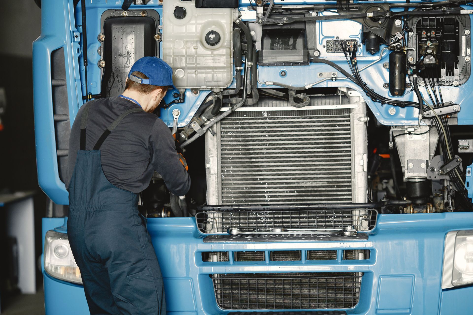 Mechanic servicing a car radiator and cooling system at AutoWits Scottsdale