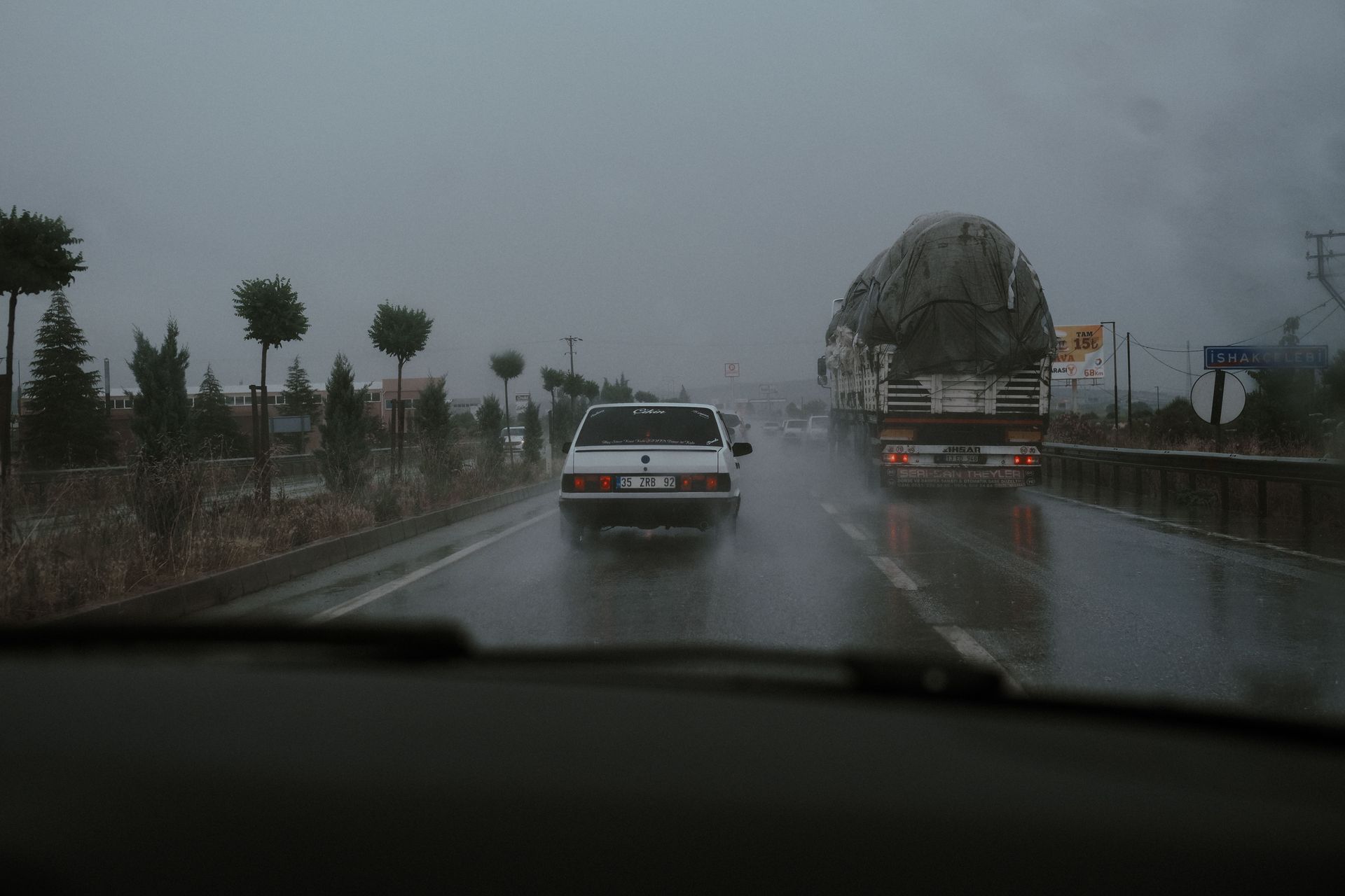 cars driving through heavy monsoon rain on a flooded Arizona road during summer storm season near Scottsdale