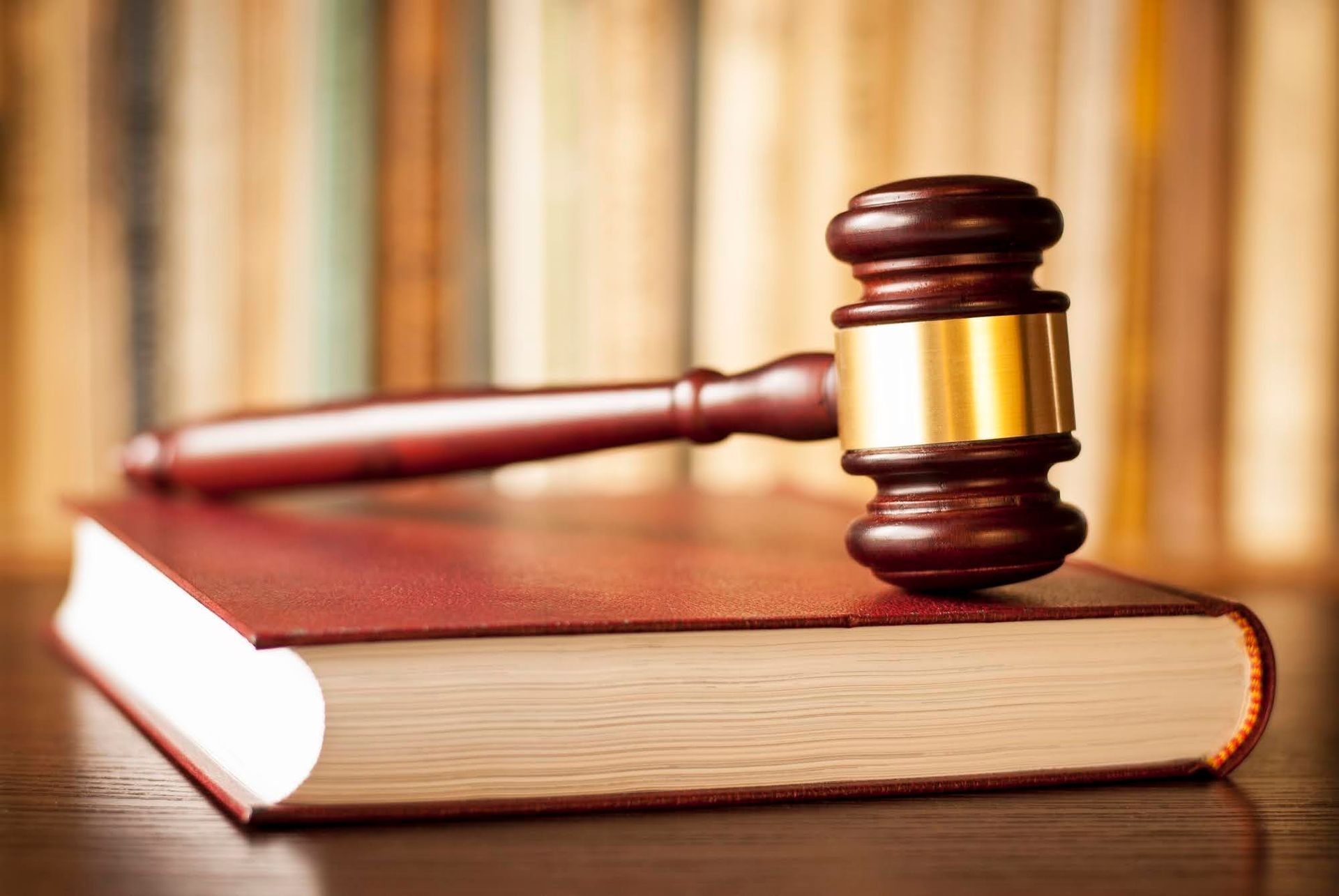 Judge is Holding a Gavel in Front of an Open Book — Eau Claire, WI — Cohen Law Offices Man Facing Computer — Eau Claire, WI — Cohen Law Offices