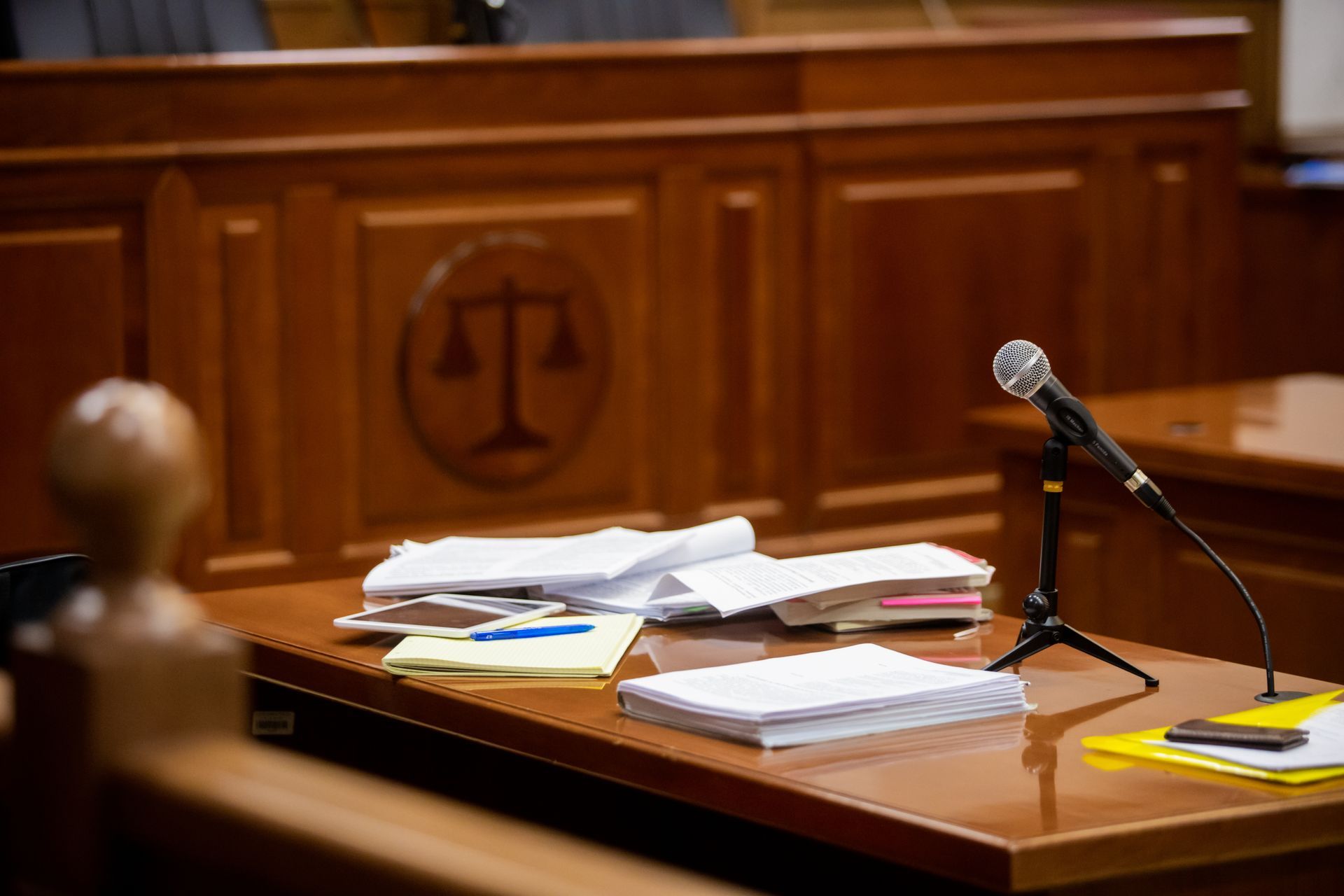 Microphone and paperwork on a courtroom desk.