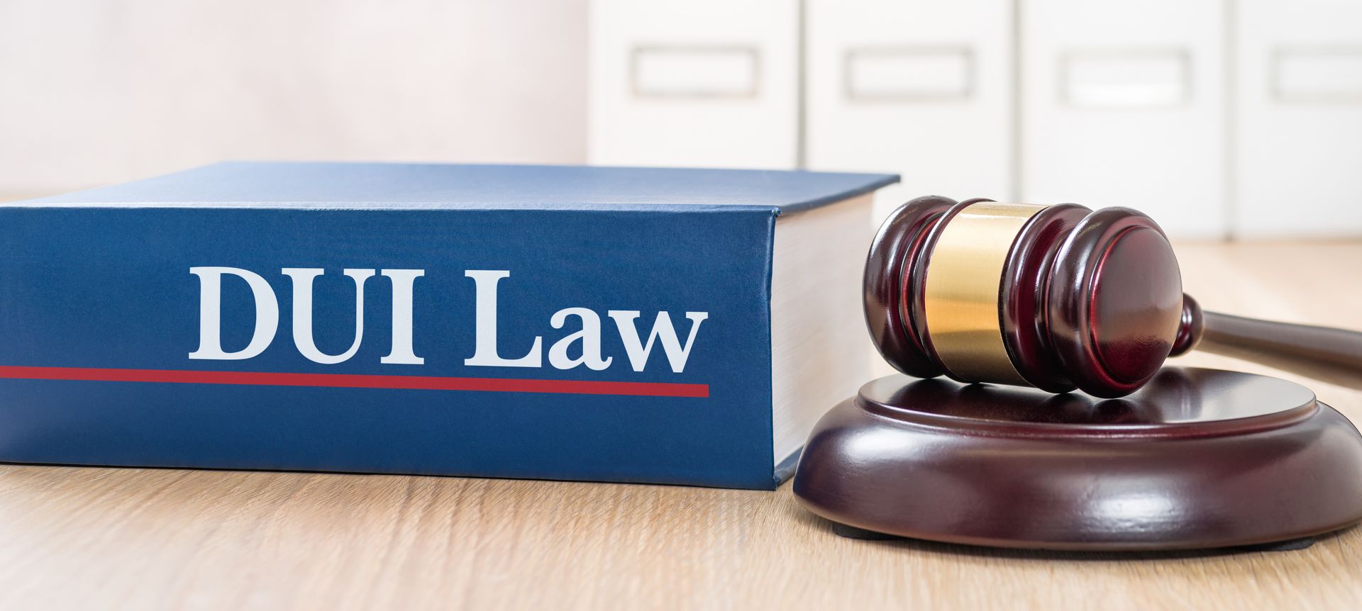 Gavel beside a large book labeled “DUI Law” on a desk. Gavel beside a large book labeled “DUI Law” on a desk.