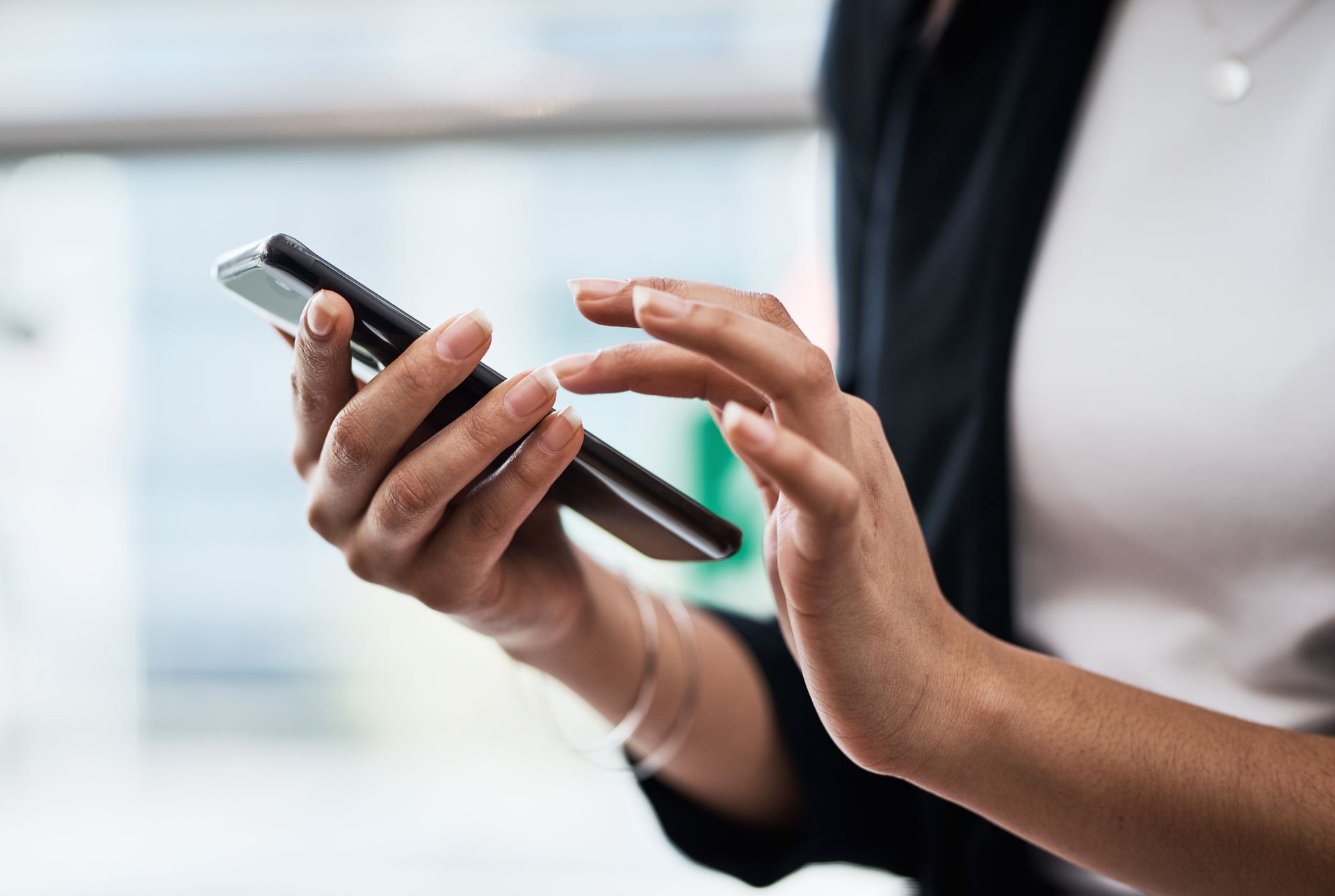 A woman is holding a cell phone in her hands — Eau Claire, WI — Cohen Law Offices A woman is holding a cell phone in her hands — Eau Claire, WI — Cohen Law Offices