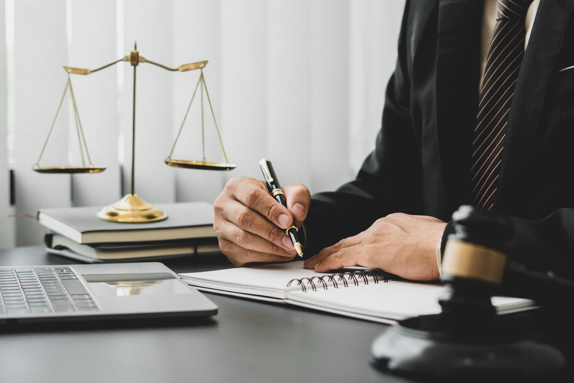 An OWI lawyer, wearing a suit, is working on a case in his office, with a scale on his desk.