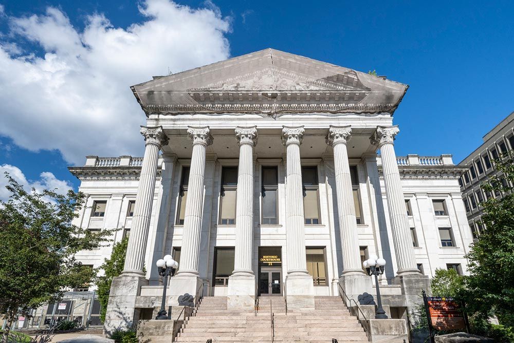 A large white building with columns and stairs in front of it. A large white building with columns and stairs in front of it.