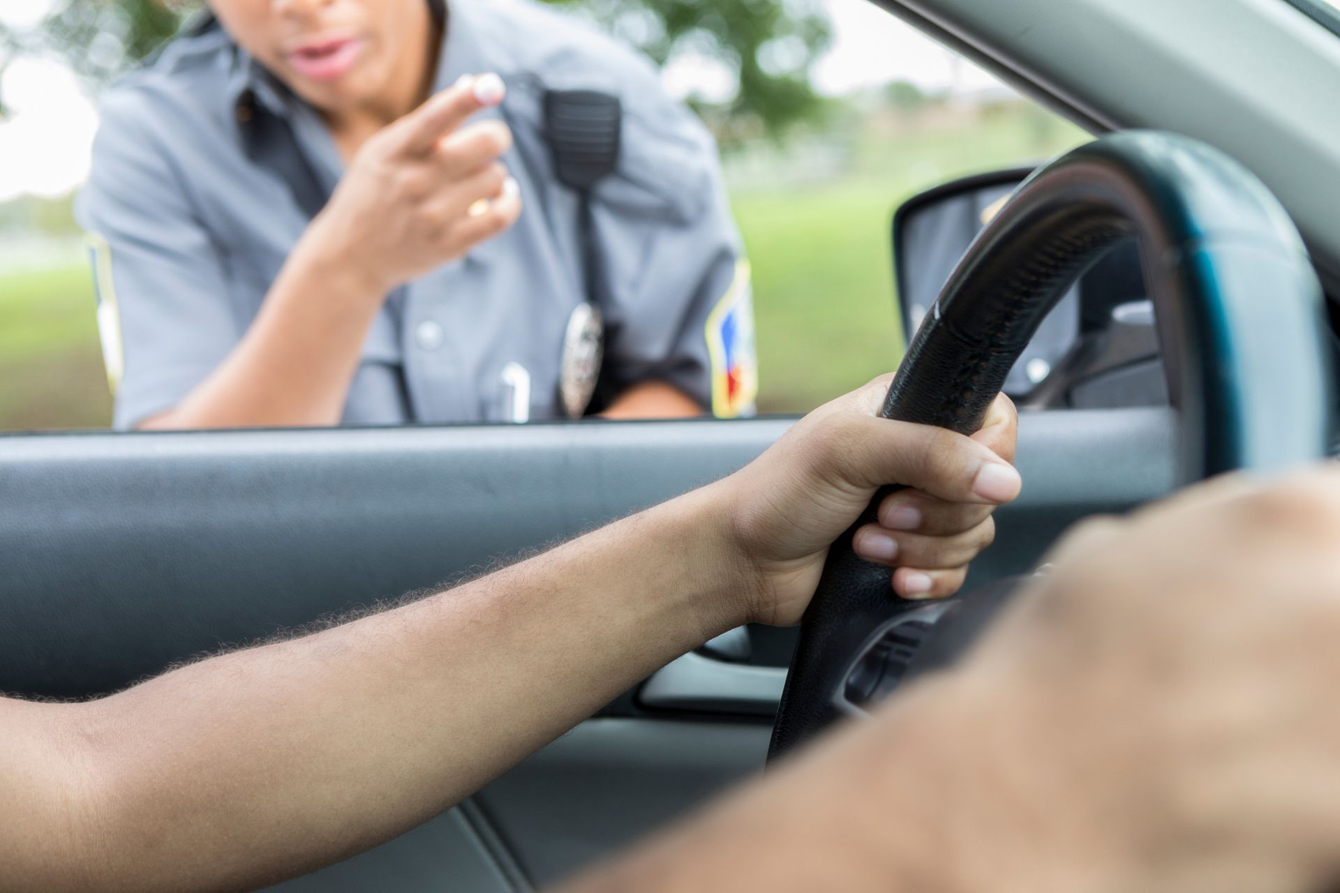 A female police officer talks with a man she pulled over. She is pointing while talking to the man. A female police officer talks with a man she pulled over. She is pointing while talking to the man.