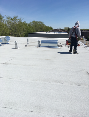 A man standing on top of a white roof