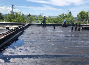 A man is standing on the roof of a building.