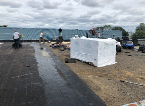 A group of people are working on the roof of a building