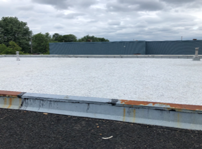 A white roof with a blue building in the background