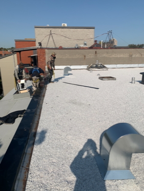 A man is standing on a white roof