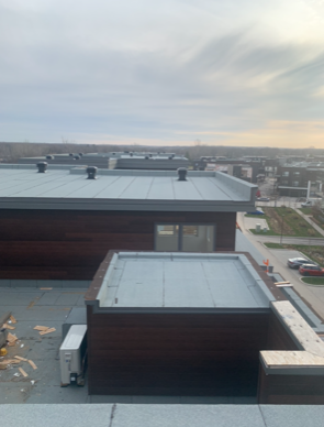 A rooftop view of a building with a lot of windows and a roof.