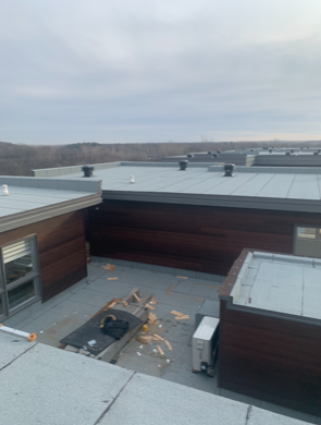 A rooftop view of a building with a gray roof