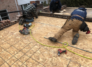 A group of men are working on a roof.