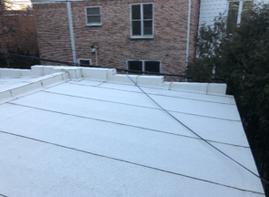 A white roof with a brick building in the background