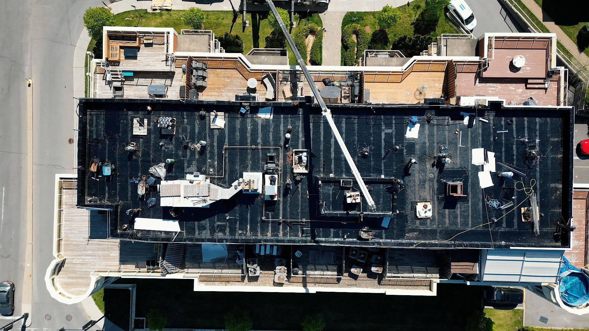 Vue aérienne d'un toit plat en construction ; une grue est présente.